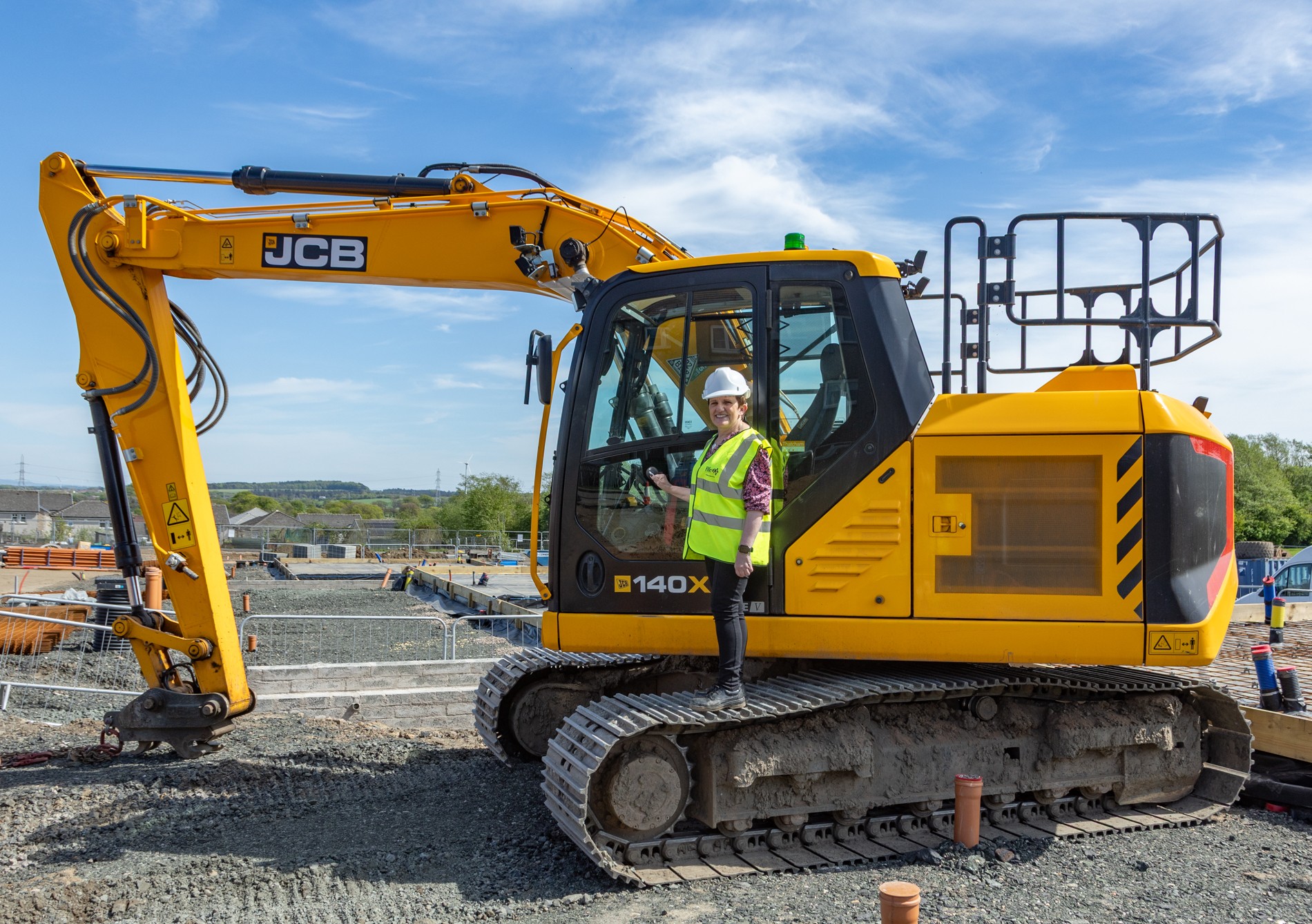 Councillor standing with JCB machine