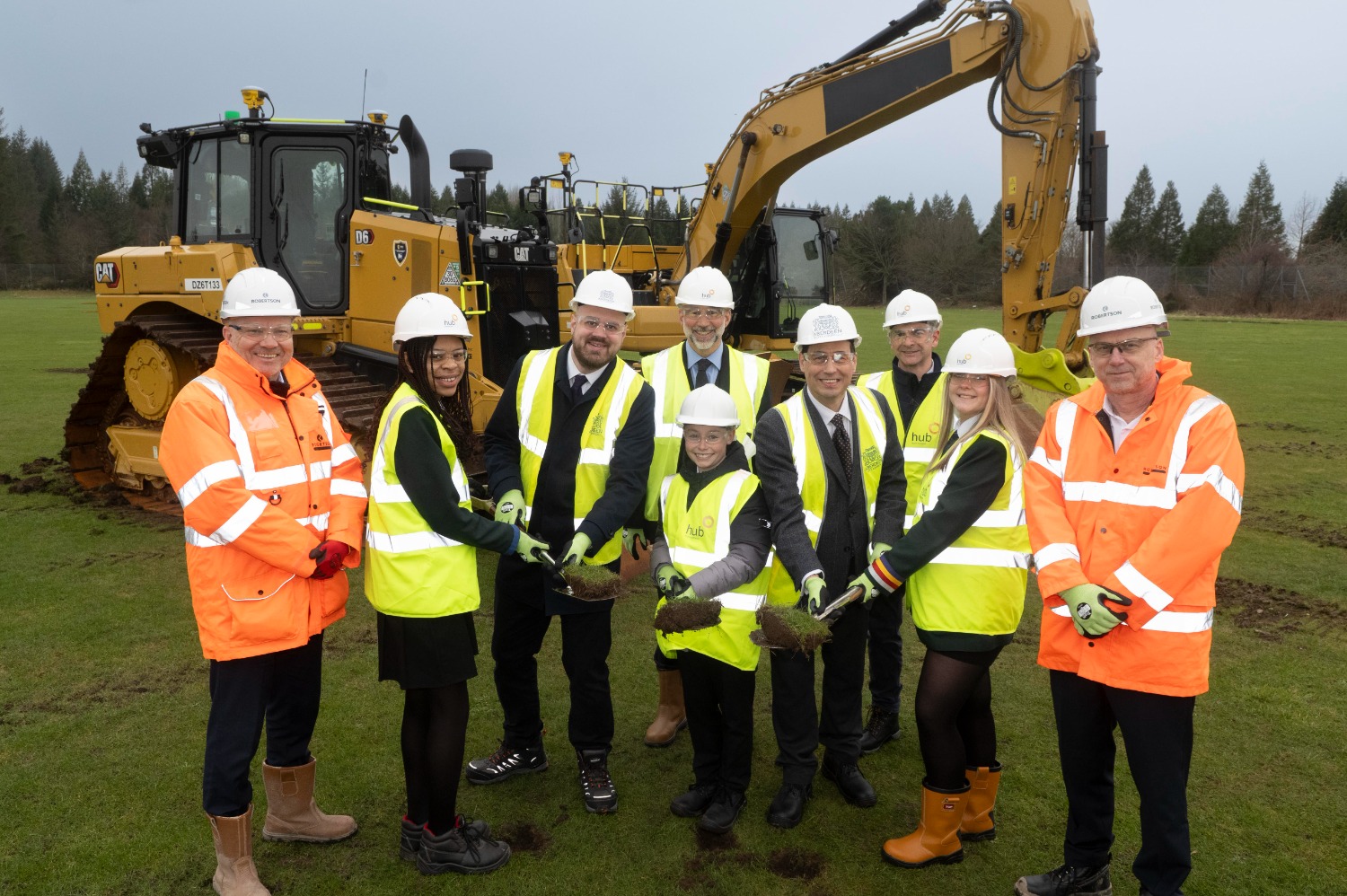 Attached image caption: Holding turf with Councillor McLellen and Councillor Greig are Hazlehead Pupils Ozi, Robert and Chloe watched by Kevin Dickson, (Robertson Group) Scott Brown, (Robertson Project Director) James Purdie, Headteacher at Hazlehead Academy and John McHardy, Project manager from hub North Scotland.