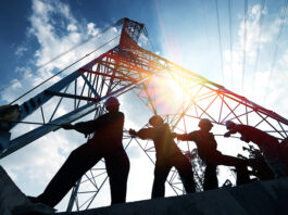 CPA downgrades construction output forecast as Middle East impact begins to bite silhouette workers on background of construction