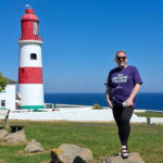 Poignant lighthouse challenge raises vital funds for construction charity Charity fundraiser standing outside lighthouse
