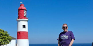 Charity fundraiser standing outside lighthouse