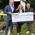 McTaggart marks anniversary year with Simon Community Scotland donation Giant cheque being handed over to charity