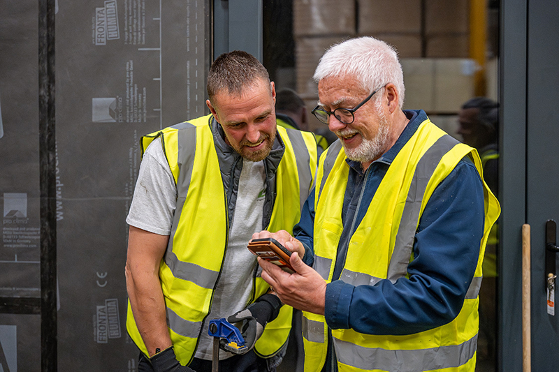Construction workers using system calculator